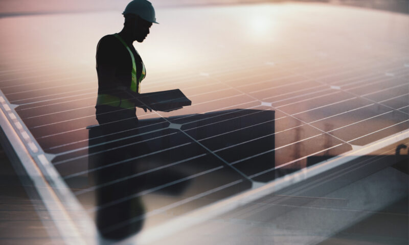 Technician standing on roof checking Photovoltaic cells panels on factory, Maintenance of the solar panels, Engineer service, Inspector concept. Double Exposure Photo.