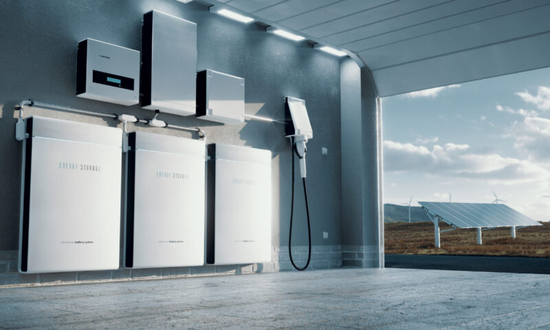 Concept of a home energy storage system based on a lithium ion battery pack situated in a modern garage with  view on a vast landscape with solar power plant and wind turbine farm. 3d rendering.